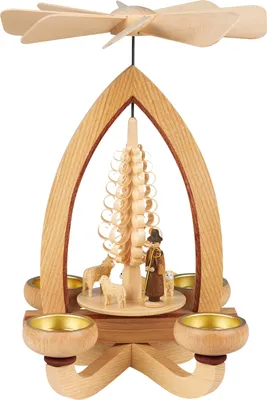 Ein kunstvoll gestaltetes Holzwindspiel zeigt eine Pyramide mit einem Schäfer und Schafen umgeben von vier Teelichthaltern und einem sich drehenden Propeller an der Spitze