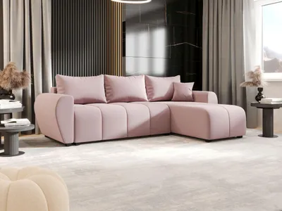 A modern living room with a pink sectional sofa, decorative pillows, and side tables.