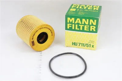 A new MANN FILTER oil filter, its packaging box, and a rubber gasket are displayed on a white background.