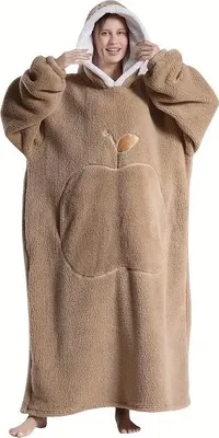 A woman wearing a large, hooded blanket with an apple design.