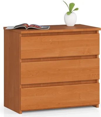 A wooden chest of drawers with three drawers, a plant in a white pot, and an open magazine on top.