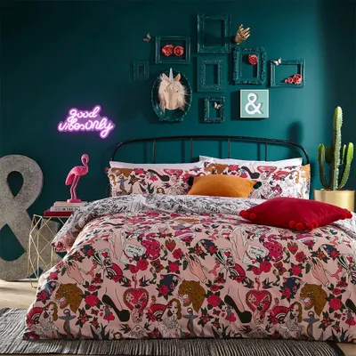 A bedroom scene with a bed, bedding, and wall decorations.
