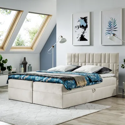 A bedroom with a bed, skylights, and artwork.
