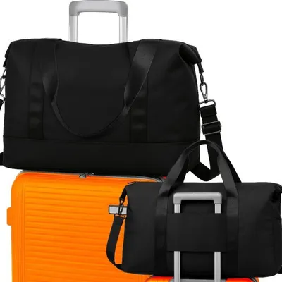 Two black duffel bags are placed on top of an orange suitcase.