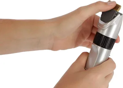 Hands holding a cordless hair clipper.