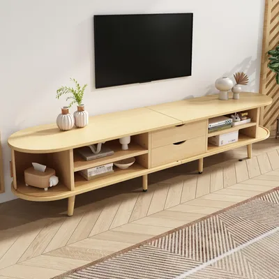 A light wood TV stand with a television mounted on the wall above it.