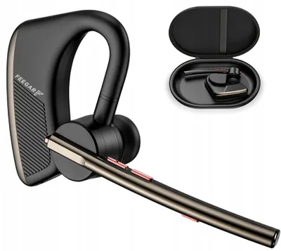 A black Bluetooth headset with gold accents is shown against a white background. A charging case containing another headset is visible in the upper right corner.