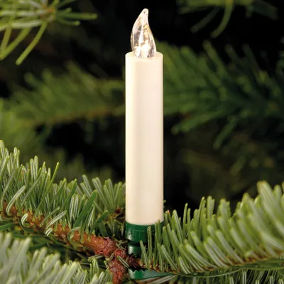 A close-up of an LED candle light attached to a Christmas tree branch.