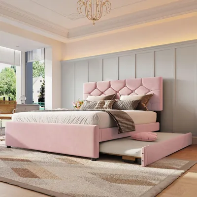 A pink upholstered bed with a pull-out trundle bed in a bedroom setting.