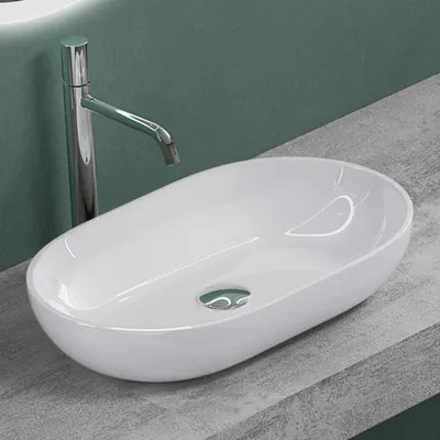 A white vessel sink with a chrome faucet is shown on a gray countertop against a green wall.