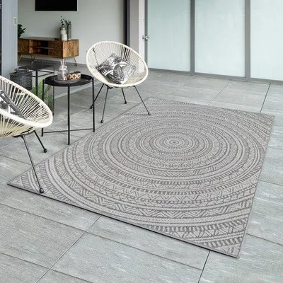 Productafbeelding van Unyqoos® vloerkleed Mistra – een robuust, weerbestendig en onderhoudsvriendelijk buitenkleed van polypropyleen, geschikt voor balkon, terras of keuken. Kleur: antraciet, met een rond etnomotief. Afmetingen: 200 x 280 cm