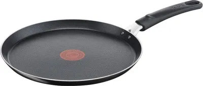 A black crepe pan with a red heat indicator in the center and a black handle, set against a white background.