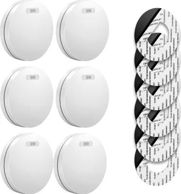 A set of six smoke detectors and several adhesive mounting pads are displayed on a white background.