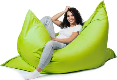 A woman is sitting on a large, lime green beanbag chair.