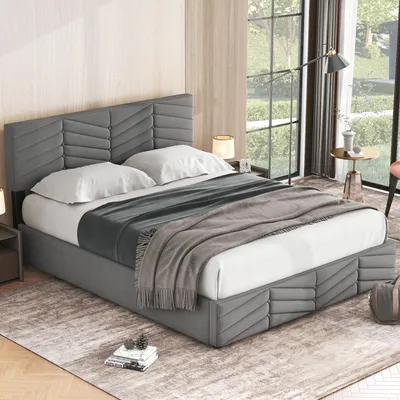 A bedroom scene featuring a gray upholstered bed with storage.