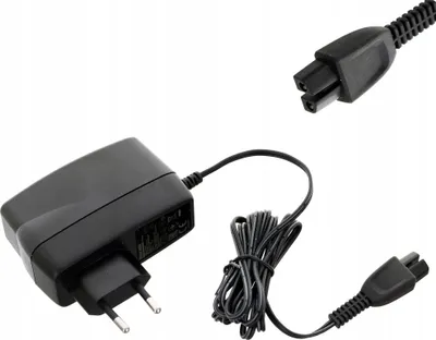 A black power adapter with a coiled cable and two different connector ends, shown against a white background.