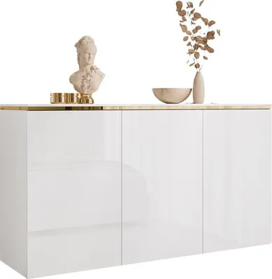 A white, high-gloss sideboard with gold trim, decorated with a bust, a bowl, and a vase with dried flowers.
