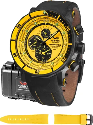 A Vostok Europe watch with a yellow dial and black leather strap, shown with its packaging and an extra yellow strap.