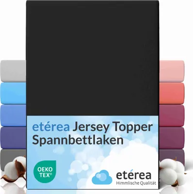 A stack of folded fitted sheets in various colors, with a black sheet prominently displayed in the front, and text overlays and cotton bolls.