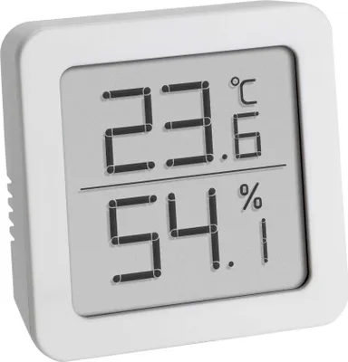 A white digital thermometer and hygrometer with a gray screen displaying temperature and humidity readings.