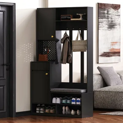 A black entryway cabinet with a bench and shoe storage, placed in a room next to a door and a sofa.