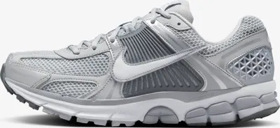 A side view of a silver Nike sneaker against a white background.