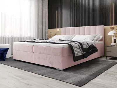 A bedroom scene featuring a pink upholstered bed.