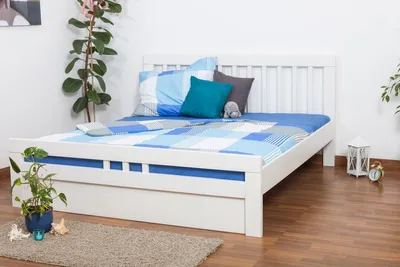 A white wooden bed with blue and white checkered bedding and pillows in a bedroom setting.