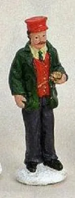 Schaffner oder Zugbegleiter. Trägt rote Kappe dunkelgrünen Mantel und rote Weste über dunklen Hemd.