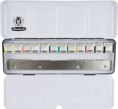 An open metal tin of Schmincke Aquarell AKADEMIE watercolors, showing 12 half pans arranged in a row.
