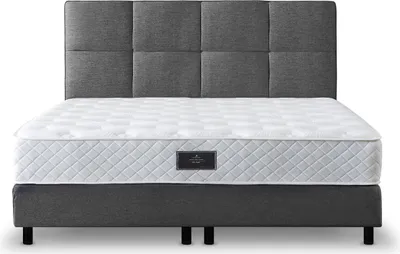 A box spring bed with a headboard and mattress.