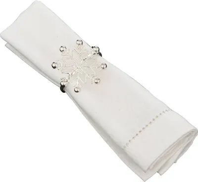 A white linen napkin folded and held by a snowflake-shaped napkin ring.