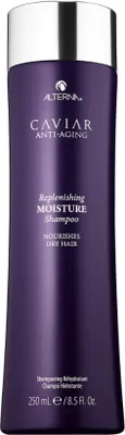 A product shot of a purple shampoo bottle with a silver cap.