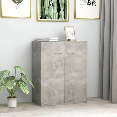A concrete-effect sideboard with two doors, placed in a room with artwork on the wall and a plant.