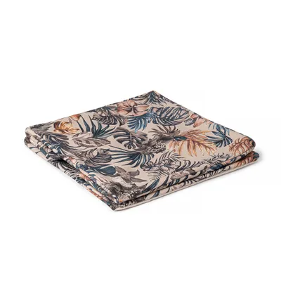 A folded textile with a tropical leaf pattern on a white background.