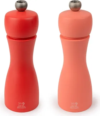 Two Peugeot pepper mills, one red and one coral, are shown against a white background.
