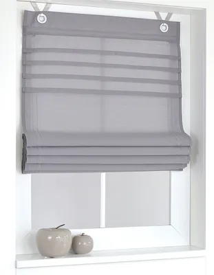 A grey Roman blind is shown hanging in a window frame, with two decorative apple-shaped objects on the windowsill below.