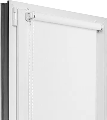 Close-up view of a white roller blind installed on a window frame.