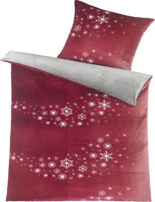 A folded duvet cover and a pillowcase with a snowflake pattern.