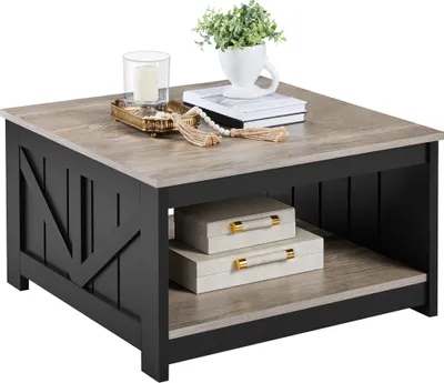 A square coffee table with a wood-look top and black base, decorated with two storage boxes and a plant.