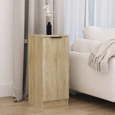 A wooden cabinet with a vase of flowers on top, placed next to a sofa.