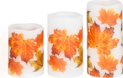 Three LED candles with autumn leaf designs are arranged side-by-side against a white background.