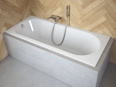 A white bathtub with a silver faucet and shower head, set against a wood-paneled wall and gray tiled floor.