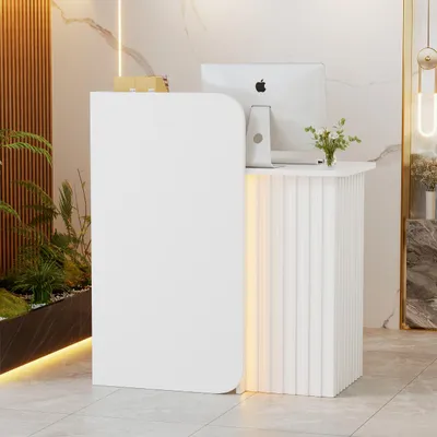 A modern white reception desk with integrated LED lighting, placed in a well-lit interior space with plants and marble accents.