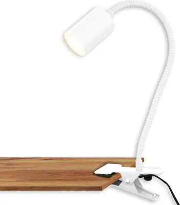 A white clip-on lamp is attached to a wooden surface.