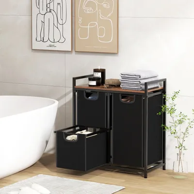 A bathroom scene with a freestanding laundry sorter, bathtub, and artwork on the wall.