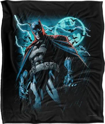 Batman standing in the rain with lightning and bats in the background.