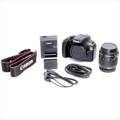 A Canon DSLR camera and its accessories are laid out on a white background.