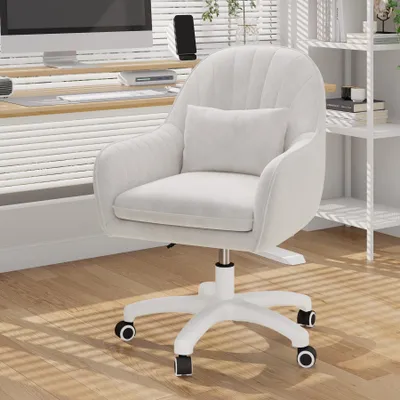 A white velvet office chair with a small pillow is shown in a well-lit room with wooden floors and blinds.