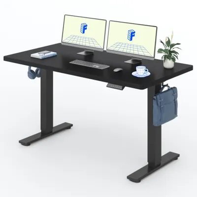 A black adjustable standing desk with two computer monitors, a keyboard, a mouse, headphones, a cup of coffee, and a bag.
